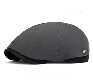 Close-up detail of dark grey newsboy hat featuring textured fabric and black brim accents