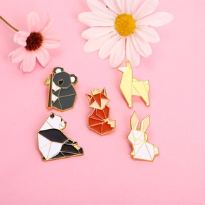 Detail view of five geometric enamel pins featuring fox and panda on pink background