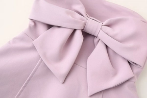 Close-up of the elegant lavender dress featuring a large three-dimensional bow detail