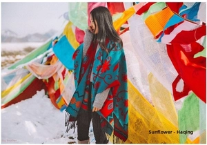 Close-up of ethnic floral pattern and black tassel detail on the teal cashmere shawl