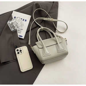Mini sage green leather bucket bag with gold hardware and dual cylindrical handles