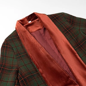 Dettaglio del cappotto a quadri verdi con colletto in velluto rosso e fodera