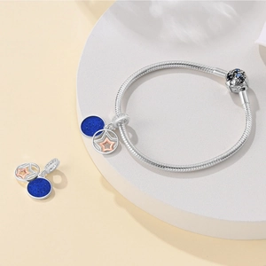 Detail of silver snake chain bracelet with sparkling blue moon and star charm pendant