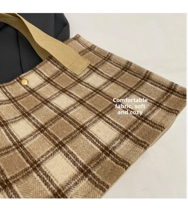 Close-up of brown plaid wool tote bag with soft texture and gold metallic button