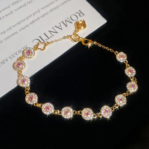 Macro view of detailed 18K gold plated bracelet featuring pink and white sparkling zircons