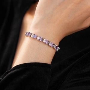 Primer plano de pulsera de plata con circonitas púrpuras y cristales en la muñeca