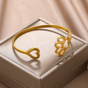 Detail of gold heart and paw print cutout on adjustable stainless steel bracelet