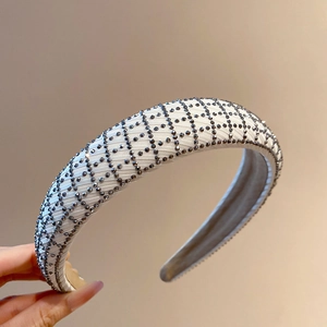 Close-up of beige mesh padded headband with grey sparkling rhinestones in grid pattern