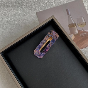 Detail of vintage square hair clip with purple and blue marble texture and gold metal base