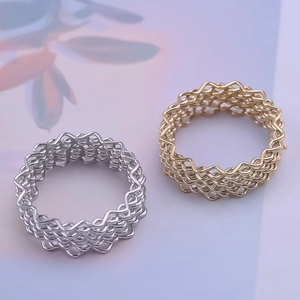 Macro shot of 304 stainless steel rings with woven wave texture in gold and silver finish