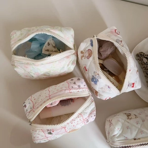 Quilted cosmetic bags with floral and bear prints featuring durable metal zippers