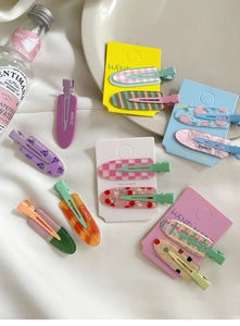 Detail of candy-colored floral and fruit print hair clips in a stylish gift set display