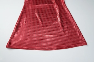 Détail macro de la texture à paillettes rouges et couture de l'ourlet sur une robe de soirée