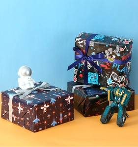 Detail of space and gaming themed gift wrapping paper with pixel art and robot motifs