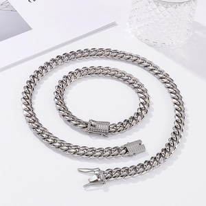Close-up of silver Cuban link chain set with rhinestone-encrusted square clasp details