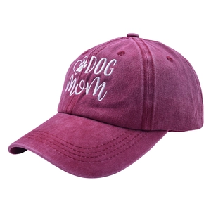 Close-up of Dog Mom white embroidery and paw print heart on washed burgundy cotton cap