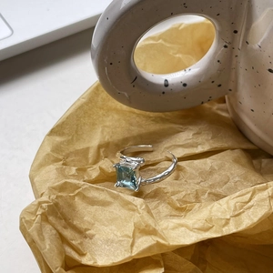 Detail of S925 silver irregular ring with blue zircon and hammered metal texture