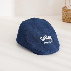 Close-up of Smile Again embroidery on dark blue denim flat cap for kids and parents