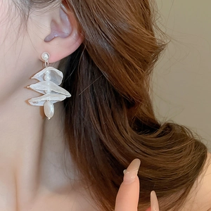 Detailed side view of elegant lace flower earrings with hanging pearls on a female model