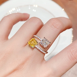 Adjustable silver ring with two square-cut yellow and white gemstones on model hand