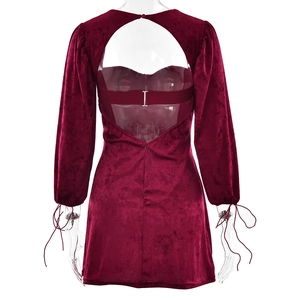 Detail of burgundy velvet mini dress showing open back cutout and lace-up cuffs
