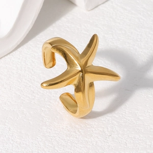 Bague étoile de mer dorée au design minimaliste sur fond blanc texturé pour femme