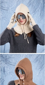 Close-up of knit balaclava with button neck and cat paw gloves in winter forest
