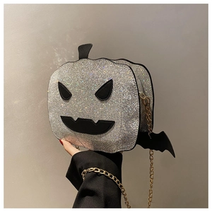Macro shot of silver glitter pumpkin bag featuring bat wings and black devil face details