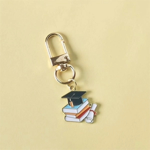 Graduation cap keychain with colorful books and diploma scroll in golden alloy finish