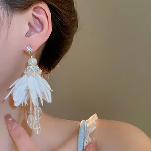 Elegant white chiffon flower tassel earrings with pearls and crystals on model