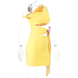 Détail de robe jaune asymétrique avec découpe à la taille et détail papillon