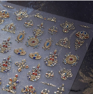 Macro view of vintage royal style nail stickers with gold embossed floral patterns