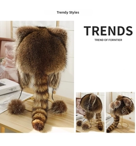 Detailed view of faux raccoon fur trapper hat with striped tail and plush pom-pom ties