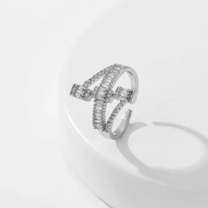 Macro view of silver adjustable double-cross ring with micro-paved baguette zircons