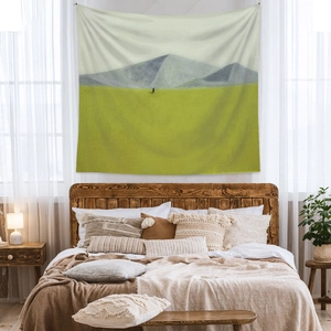 Detail of bohemian tapestry featuring minimalist mountain landscape in cozy bedroom setting