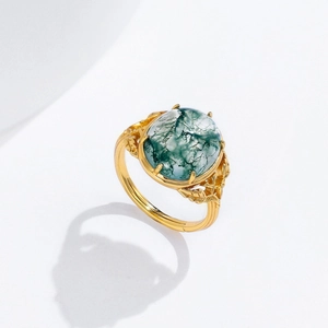 Detailed macro view of retro 925 silver ring with oval moss agate and carved leaf texture