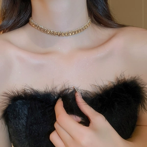 Detailansicht der goldenen Halskette mit rundem Diamantanhänger am Hals des Models