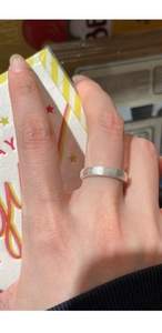 Macro detail of silver minimalist ring with brushed matte texture and wide surface