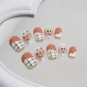 Cute large eyes press-on nails with warm orange plaid pattern and cartoon smiley face art