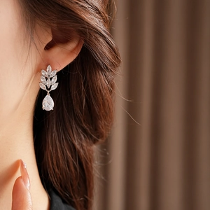 Close-up of model wearing silver zircon wheat ear drop earrings with crystal leaf design