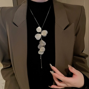 Halskette mit silbernen Ginkgo-Anhängern getragen zu braunem Blazer und schwarzem Rollkragen