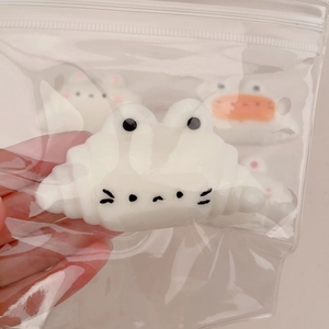 Close-up of cute white cat-shaped squishy toy in clear packaging for stress relief