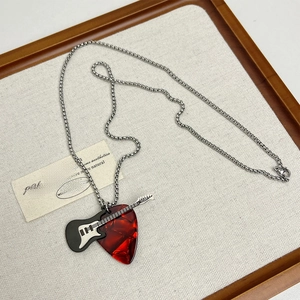 Detail of miniature electric guitar and red celluloid pick pendant on a steel chain