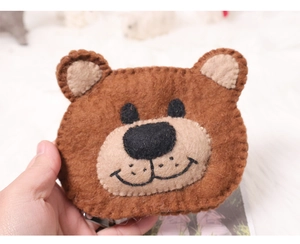 Close-up of a handmade brown wool felt bear coin purse held in hand with soft texture