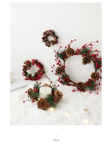 Detailed view of Christmas candle holder ring with red berries, pine cones and pine needles