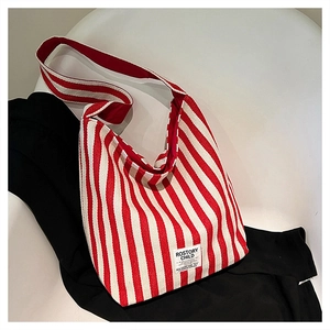 Close-up of red and white striped canvas tote bag with ROSTORY CHILD fabric label