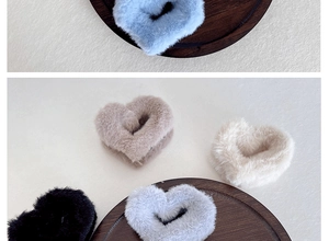 Gros plan de pinces à cheveux en peluche en forme de cœur de différentes couleurs sur bois