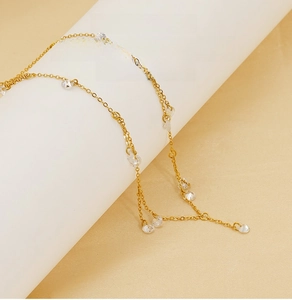 Detailed close-up of a gold-plated stainless steel necklace with sparkling zircon tassels