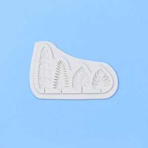 Detailed macro view of four unique tropical leaf patterns in white silicone cake mold