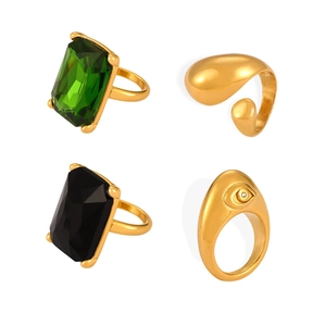 Set of four gold-plated textured rings featuring emerald cut gems and evil eye design